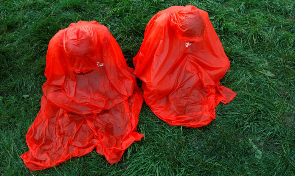 Dos peregrinos enfundados en chubasqueros rezan antes de la ceremonia de apertura del Día de la Juventud en Cracovia, Polonia. REUTERS/David W Cerny