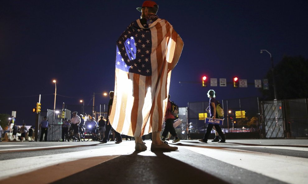 Un partidario del ex candidato presidencial demócrata, el senador Bernie Sanders, viste a modo de capa una bandera de Estados Unidos cerca del Centro de Wells Fargo en Filadelfia. REUTERS/Dominick Reuter.
