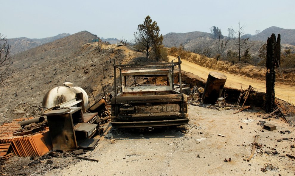 Un coche calcinado en un incendio en California (EEUU) que ha destruído una casa por completo/REUTERS