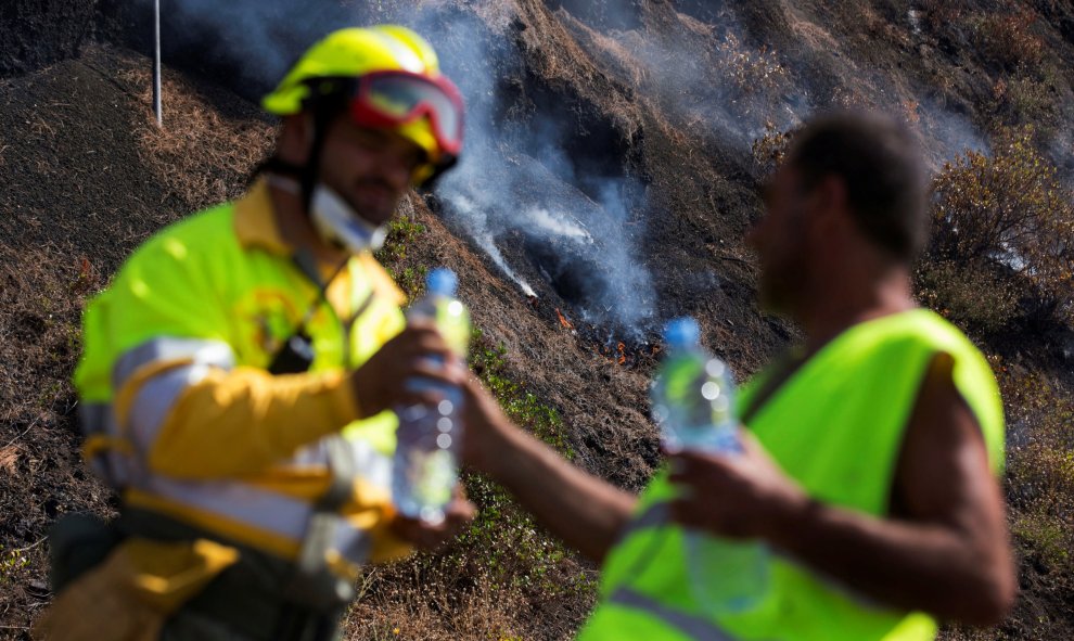 Un bombero bebe agua mientras trabaja en la extinción del fuego de Fuencaliente. REUTERS/Borja Suarez