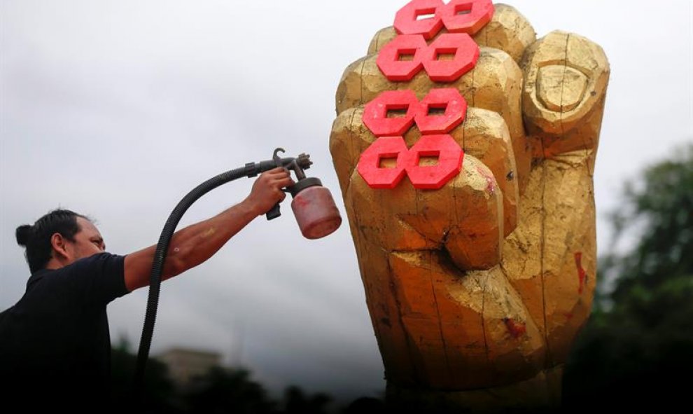 Un hombre pinta una escultura durante los preparativos para el 28 aniversario del "Levantamiento 8888" en Rangún (Birmania). El "Levantamiento 8888", como se conocen a las protestas que el 8 de agosto de 1988, terminó de manera sangrienta durante un golpe