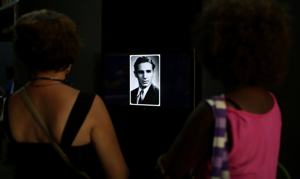 Un par de personas observan un retrato de Fidel Castro joven, que forma parte de la exposión 'Fidel', con motivo del 90 cumpleaños del líder de la revolución cubana. REUTERS/Alexandre Meneghini