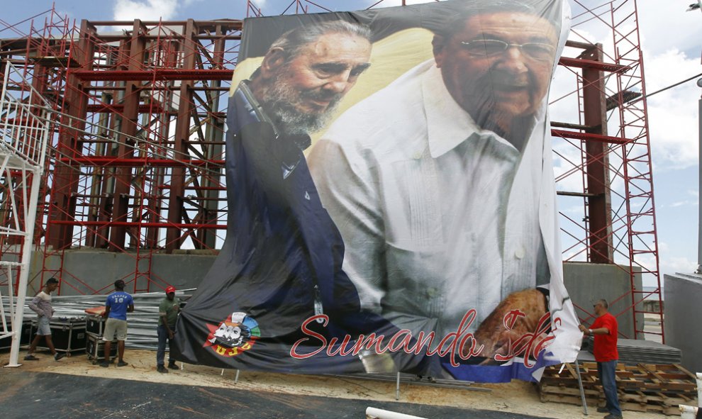 Varios obreros despliegan en La Habana una imagen gigante del presidente cubano Raúl Castro, junto a su hermano y líder de la revolución cubana Fidel Castro, con motivo de su 90 cumpleaños. EFE/Ernesto Mastrascusa
