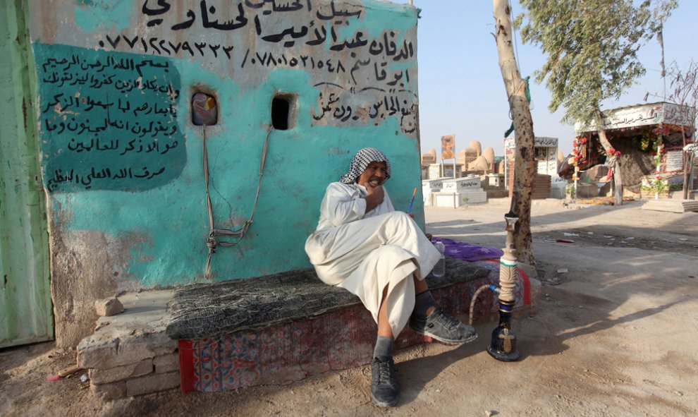 Un enterrador fuma una 'shisha' en el cementerio de Wadi al-Salam (el 'Valle de la Paz'), en Nayaf, al sur de Bagdad. REUTERS / Alaa Al-Marjani