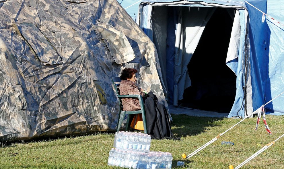Una mujer permanece sentada en un campamento improvisado en Amatrice. REUTERS/Stefano Rellandini