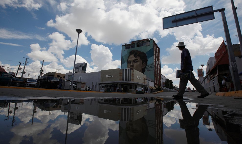 Un hombre cruza una calle mientras observa un mural del icónico cantante mexicano Juan gabriel, en Ciudad Juárez, México. REUTERS/Jose Luis Gonzalez