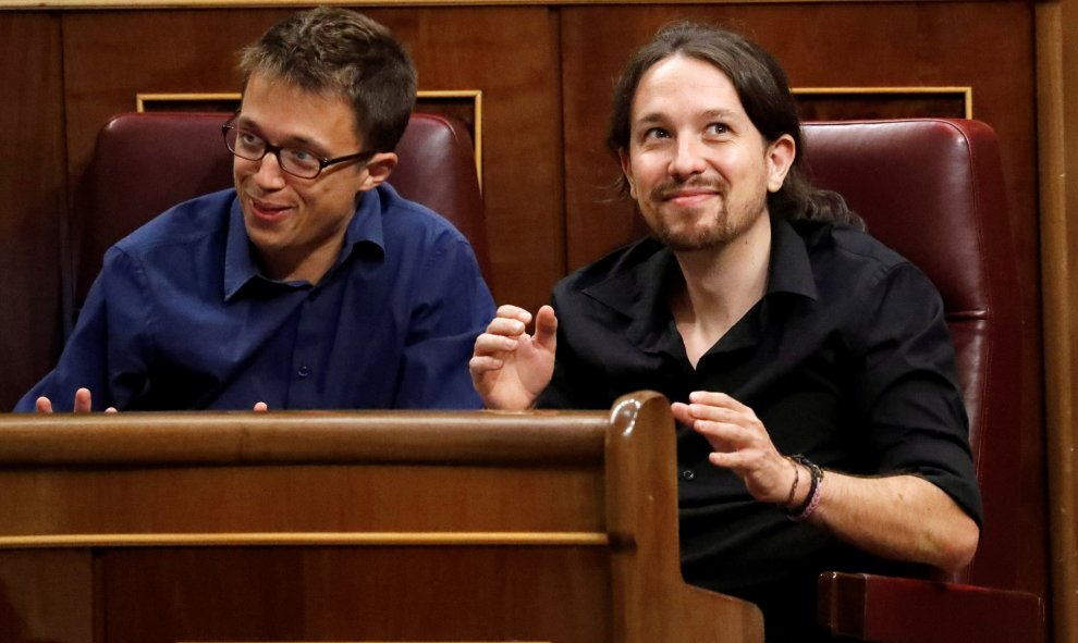 Íñigo Errejón y Pablo Iglesias, integrantes de Podemos, reaccionan ante el discurso del presidente del Gobierno en funciones, Mariano Rajoy, durante la sesión de investidura. REUTERS/Juan Medina