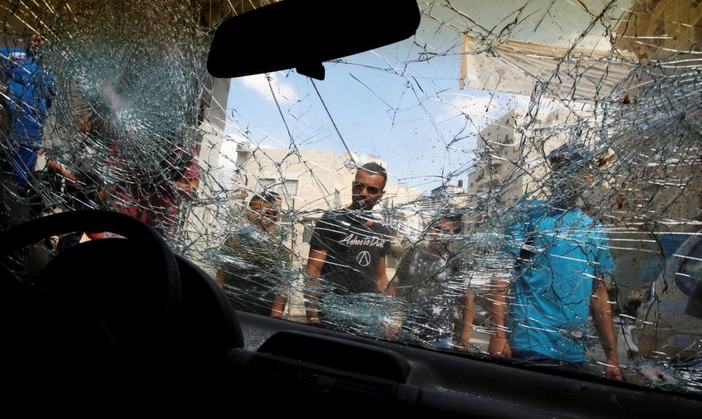 Palestinos rodean el coche de Mustafa Nimer, que fue asesinado a tiros esta mañana por las fuerzas de seguridad israelíes, en el campo de refugiados de Shuafat, cerca de Jerusalén. REUTERS / Ammar Awad