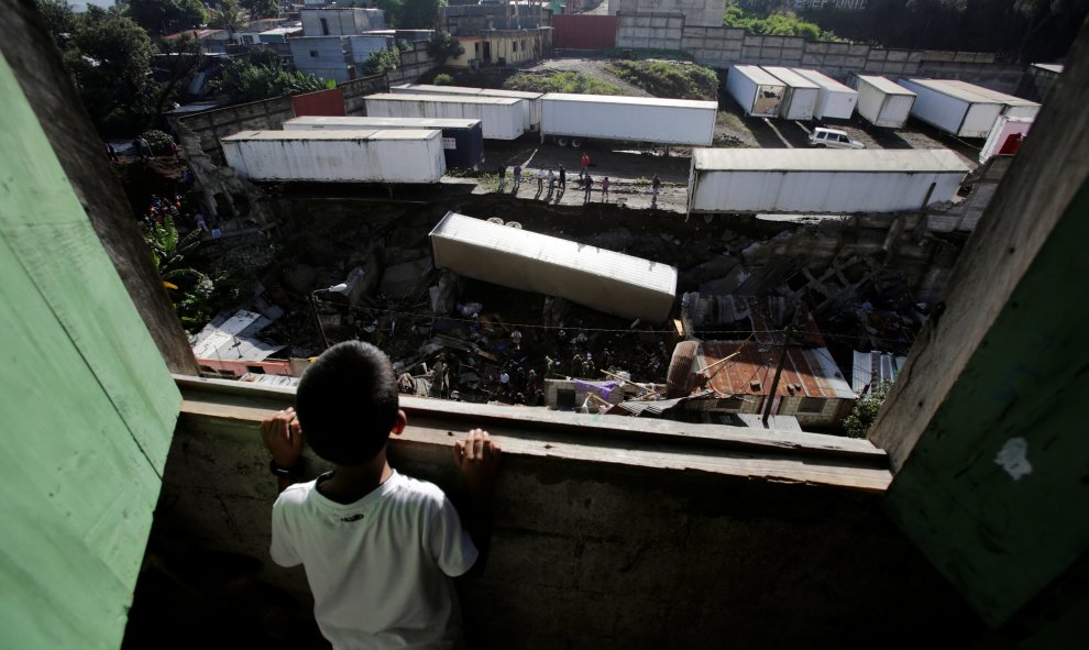 Un niño mira en el lugar donde se produjo un deslizamiento de tierra  causando varias bajas en Villanueva, Guatemala. REUTERS/Saul Martinez