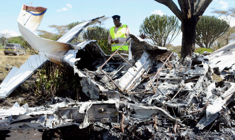 Un policía examina los restos de una avioneta que se estrelló en la granja santuario, matando a una mujer polaca y dejando heridas a otras cinco personas, incluido el piloto, en Naivasha, Kenia. REUTERS/Stringer