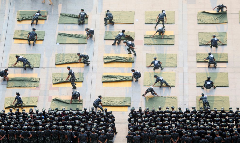 Estudiantes universitarios participan en un concurso de edredones plegables durante un entrenamiento militar en el inicio de un nuevo semestre en Hengyang, China. REUTERS