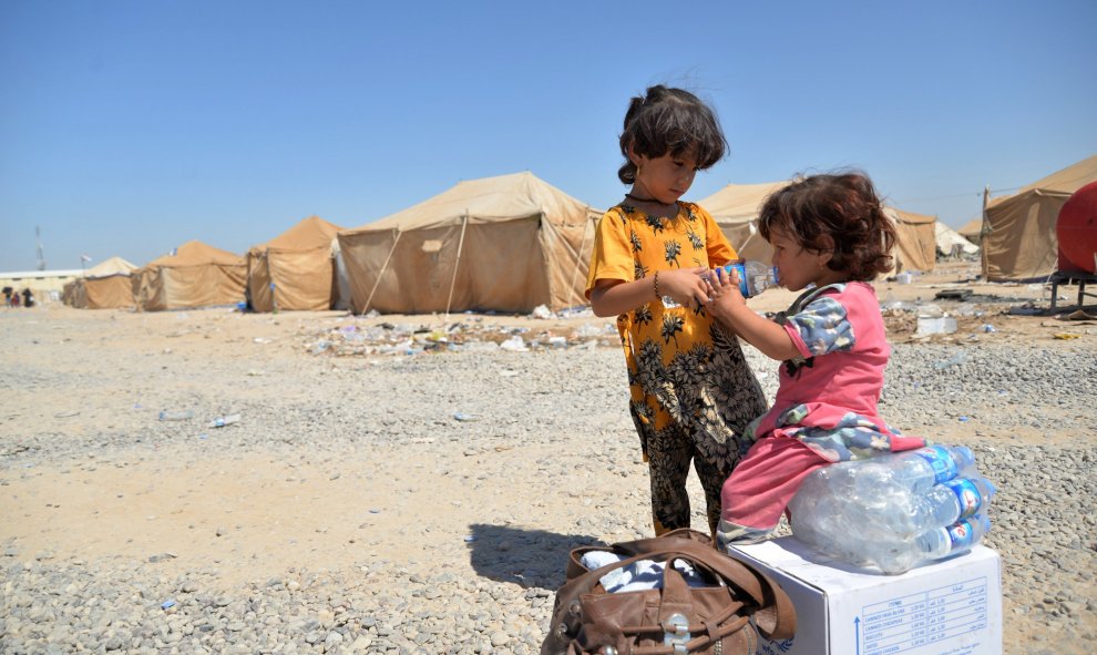 Niños iraquíes migrantes desde Siria reciben suministros de ayuda en un campamento de refugiados en Baiji, al norte de Bagdad. REUTERS/Stringer