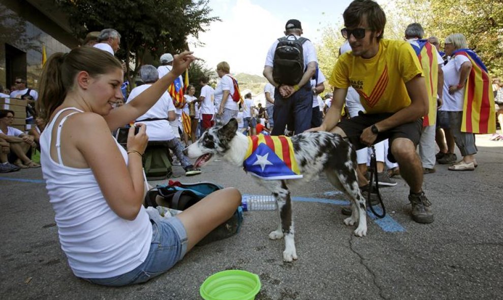 Varios jóvenes juegan con su perro momentos antes de la manifestación en el Paseo de la Pau de Berga. EFE/Susanna Sáez