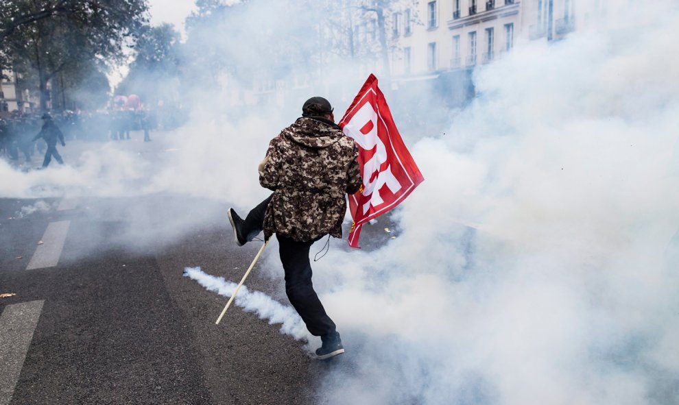 Un manifestante devuelve un bote de gas de lacrimógeno durante una manifestación contra la nueva reforma laboral en París.- EFE/Ian Langsdon