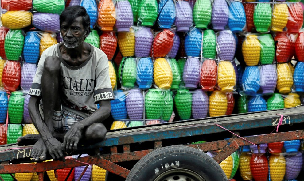 Un hombre descansa en su carro después de descargar jarras de plástico cerca de una tienda en un mercado en Colombo, Sri Lanka. REUTERS/Dinuka Liyanawatte