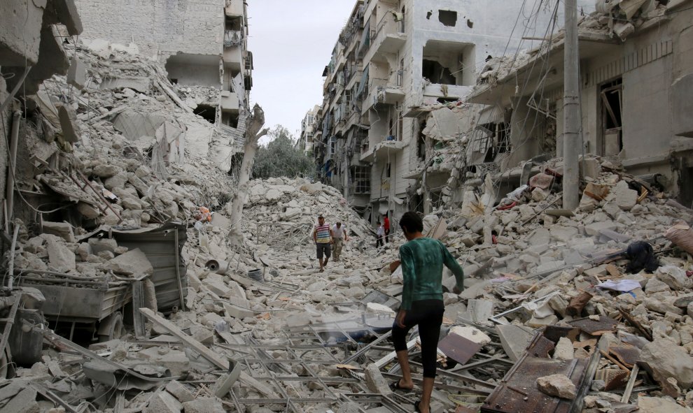 Un grupo de personas inspecciona un sitio dañado después de ataques aéreos contra los rebeldes realizaron en el barrio Tariq al-Bab de Alepo, Siria. REUTERS/Abdalrhman Ismail