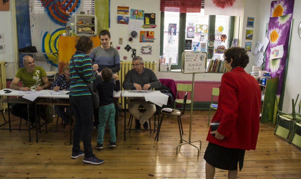 Algunos electores ejercen su derecho al voto en el colegio de la Escuela de Artes y Oficios de Vitoria. EFE/David Aguilar