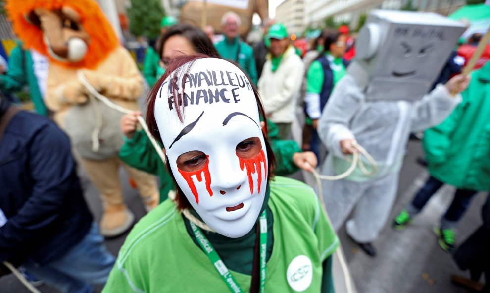 Una mujer lleva una máscara durante la protesta por las reformas del gobierno y las medidas de reducción de costes en Bruselas. REUTERS/Yves Herman