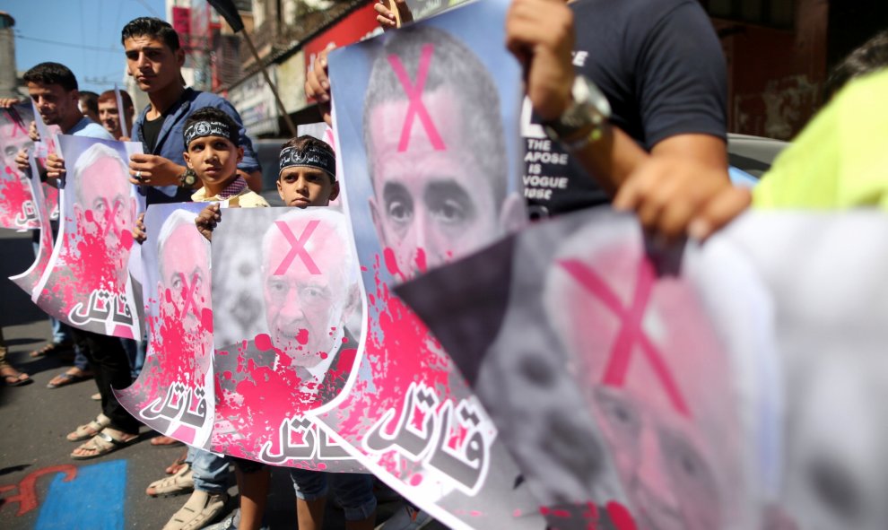 Palestinos pintan y queman carteles de Barack Obama y del primer ministro israelí, Benjamin Netanyahu, durante una manifestación después de las oraciones del viernes en la ciudad de Gaza/REUTERS