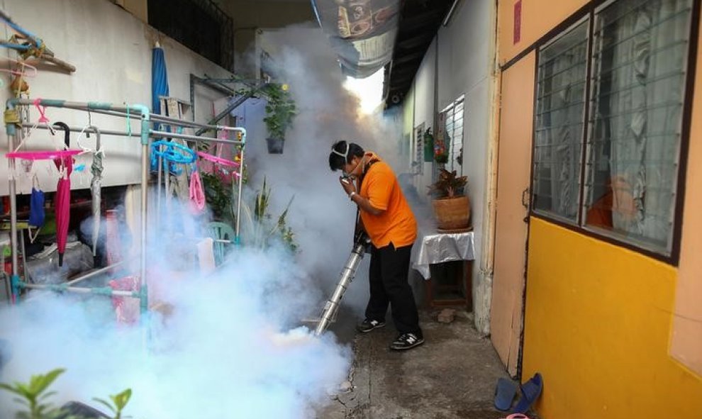 Un hombre fumiga las afueras de un colegio en Bangkok por el aumento de mosquitos que transmiten el virus del Zika/REUTERS