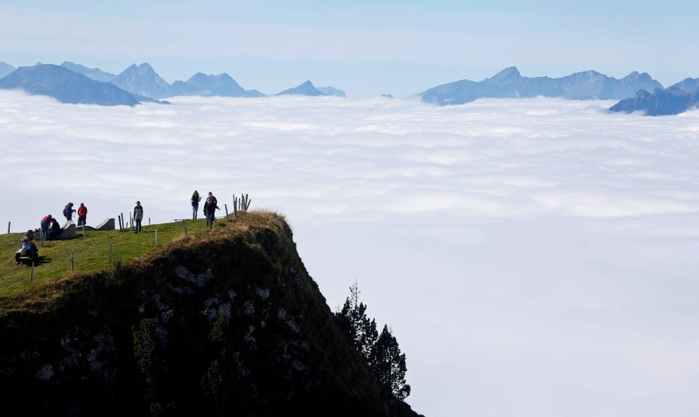 Los turistas caminan bajo el sol en la montaña Niederhorn, cerca de Interlaken, Suiza. REUTERS / Ruben Sprich