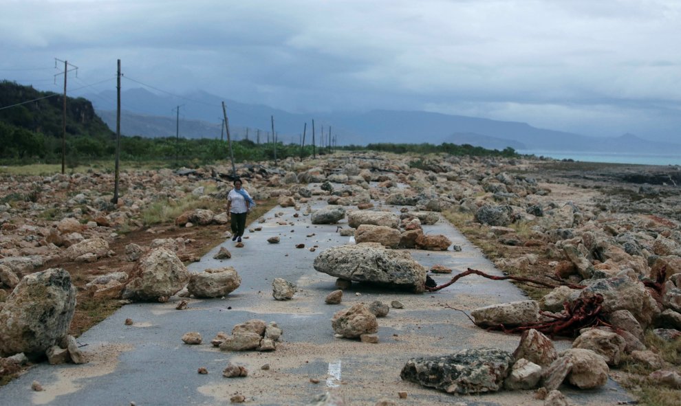 Una mujer camina en una carretera bloqueada por rocas tras el paso del huracán Mateo en la costa de la provincia de Guantánamo, Cuba. REUTERS / Alexandre Meneghini