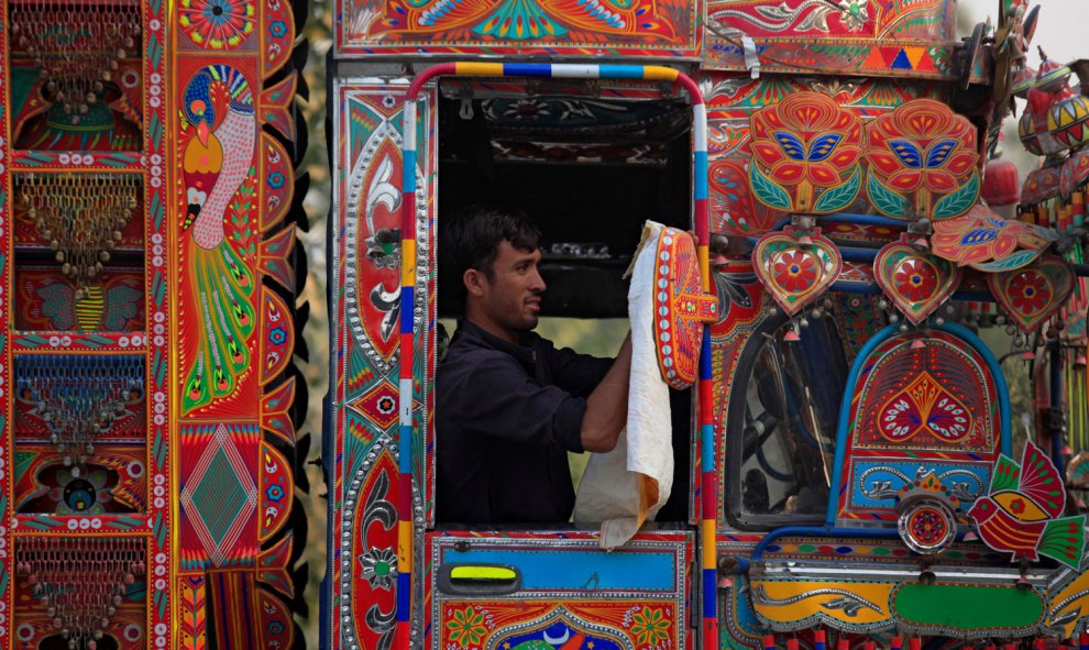 Un hombre limpia el espejo de su camión llamativamente decorado en Charsadda a las afueras de Peshawar, Pakistán. /REUTERS