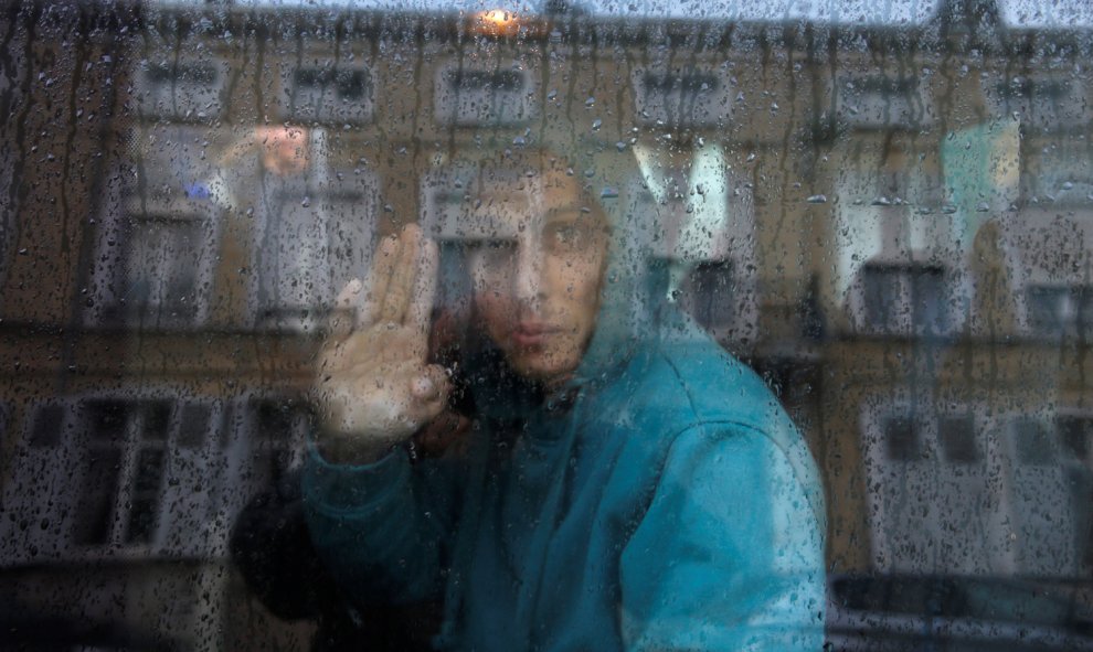 Una adolescente afgana en el reflejo de una furgoneta mientras la trasladan junto a otros seis inmigrantes del centro para menores de edad de Saint Omer. / REUTERS