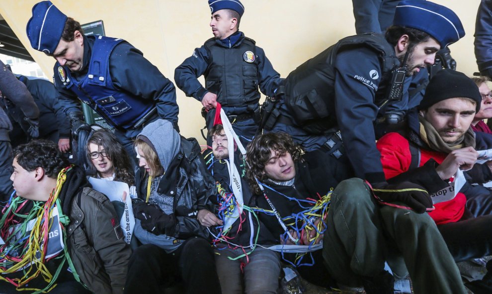 Policías se enfrentan a varios activistas que bloquean el acceso a la sede de la Comisión Europea durante una protesta contra las subvenciones europeas a la industria armamentística en Bruselas (Bélgica). EFE/Stephanie Lecocq