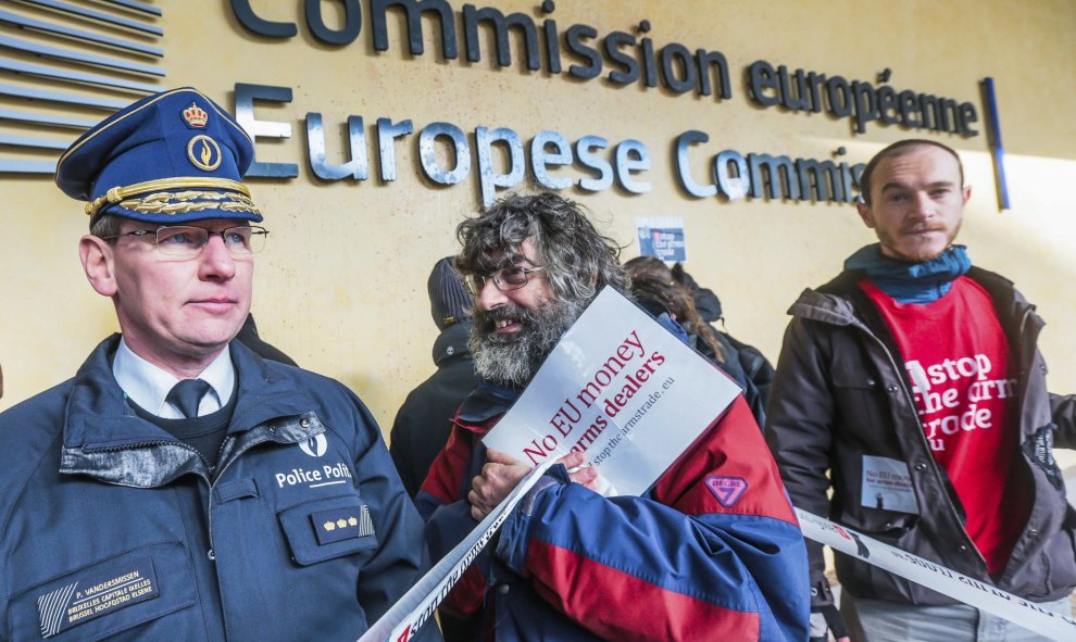 Activistas protestan ante el acceso a la sede de la Comisión Europea contra las subvenciones europeas a la industria armamentística en Bruselas (Bélgica). La policía decidió cerrar el barrio como medida de seguridad. EFE/Stephanie Lecocq