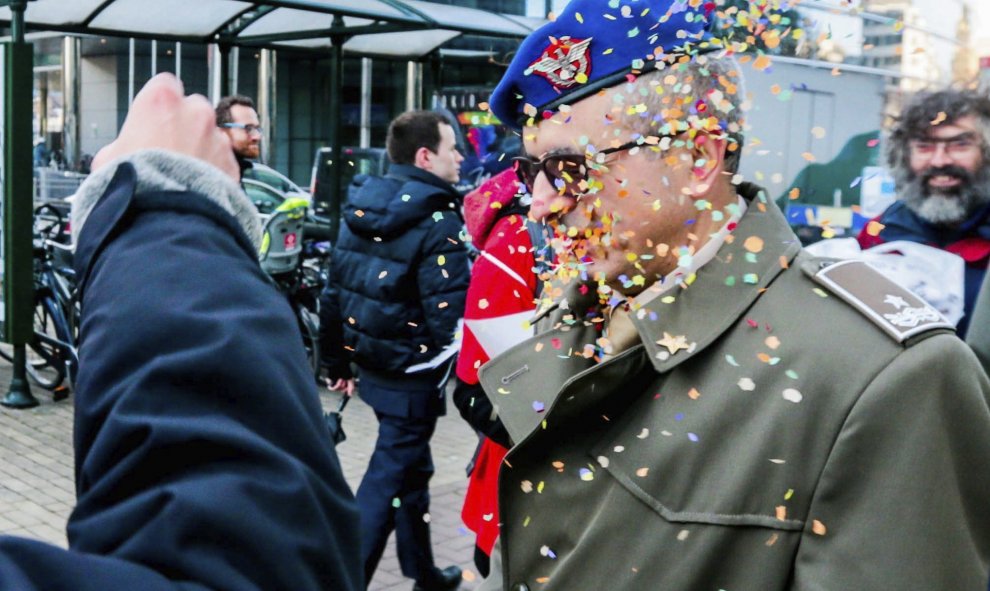 Un activista arroja confeti a un soldado delante de la sede de la Comisión Europea para protestar contra las subvenciones europeas a la industria armamentística en Bruselas (Bélgica). EFE/Stephanie Lecocq