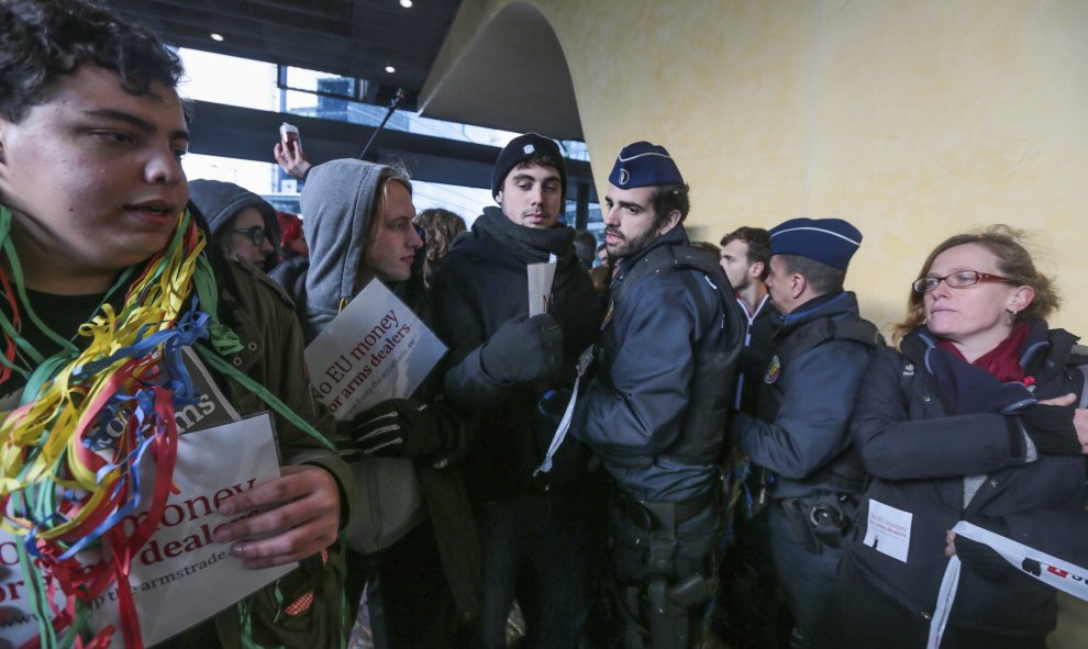 Policías se enfrentan a varios activistas que bloquean el acceso a la sede de la Comisión Europea durante una protesta contra las subvenciones europeas a la industria armamentística en Bruselas (Bélgica. EFE/Stephanie Lecocq