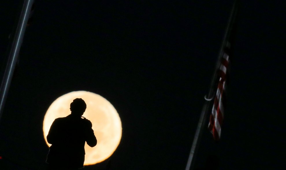 Un hombre toma una fotografía de la superluna en Washington / REUTERS