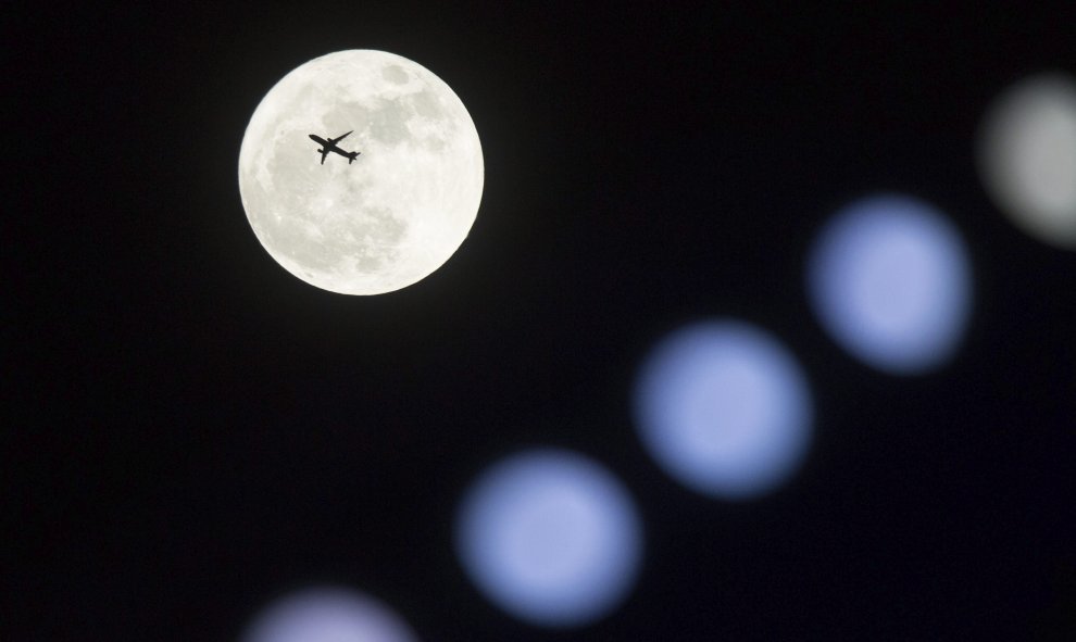 Un avión vuela frente a la superluna en Hong Kong (China). EFE/Jerome Favre