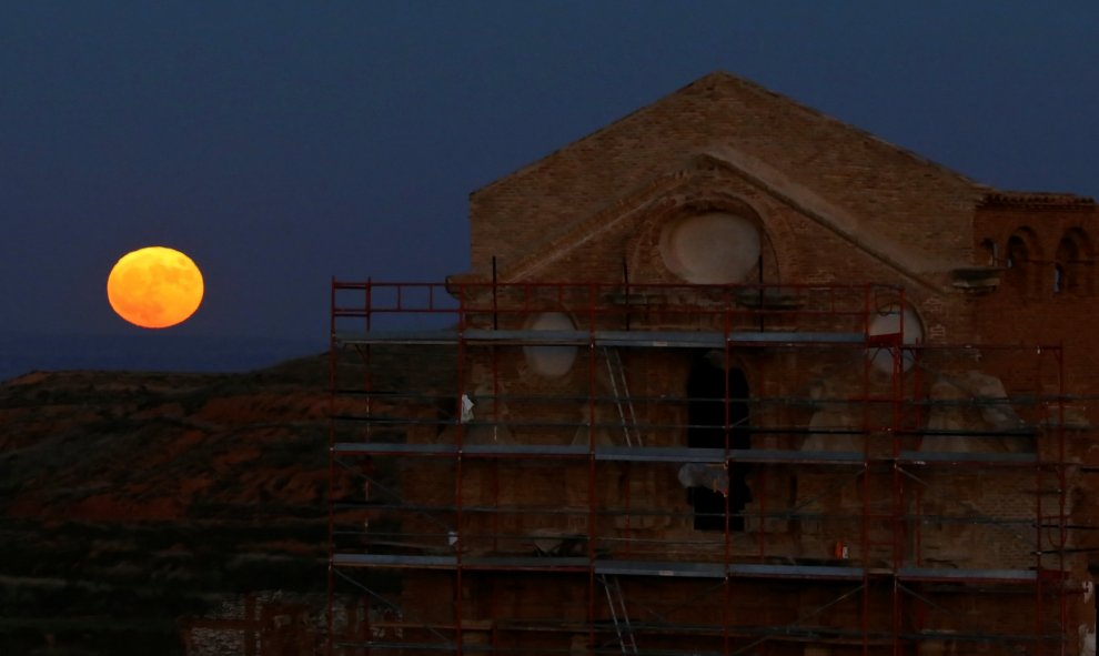 La superluna se alza sobre la iglesia de San Martin de Tours en Belchite. REUTERS/Andrea Comas