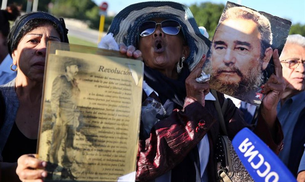Dos mujeres muestran retratos del fallecido líder cubano Fidel Castro, durante un homenaje póstumo en la Plaza de la Revolución de La Habana (Cuba). EFE