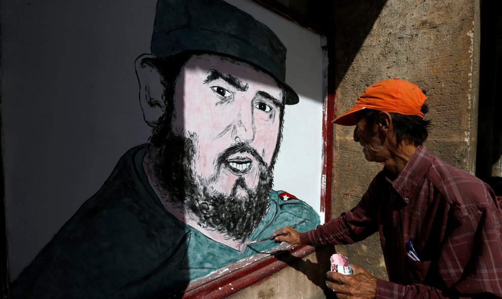 Un artista pinta un retrato de Fidel Castro enfrente de una tienda en la Habana. REUTERS