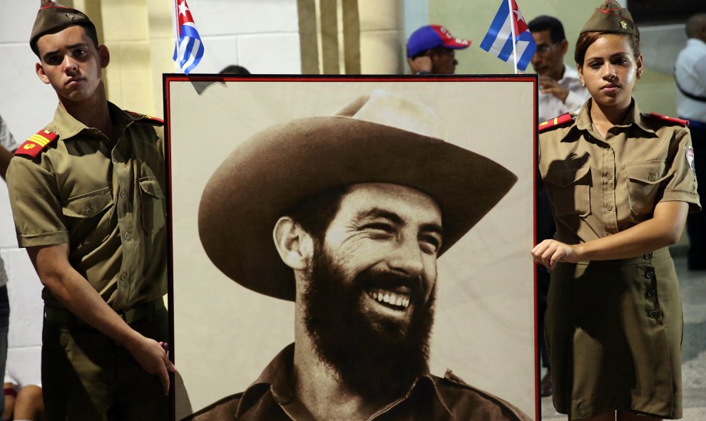 Dos personas portan un retrato de Fidel Castro, mientras llega la caravana con las cenizas del fallecido líder de la revolución cubana por la ciudad de Bayamo. EFE/Alejandro Ernesto