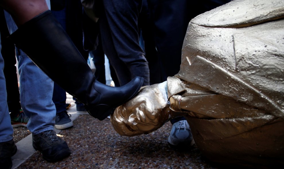 Una mujer patea la estatua satírica derruida de Netanyahu. REUTERS/Baz Ratner