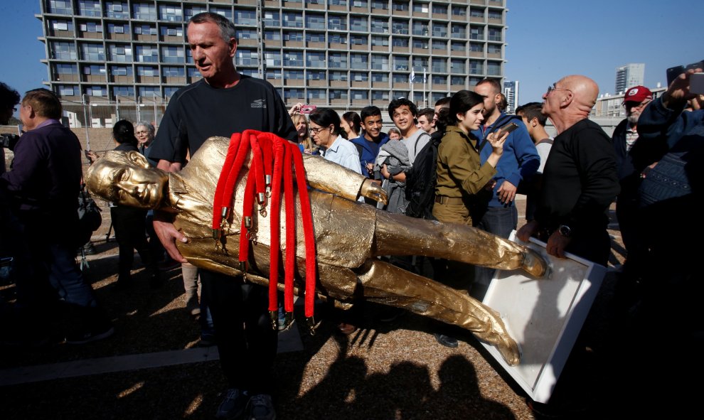 Un hombre sujeta la estatua satírica contra el primer ministro de Israel Benjamin Netanyahu. REUTERS/Baz Ratner