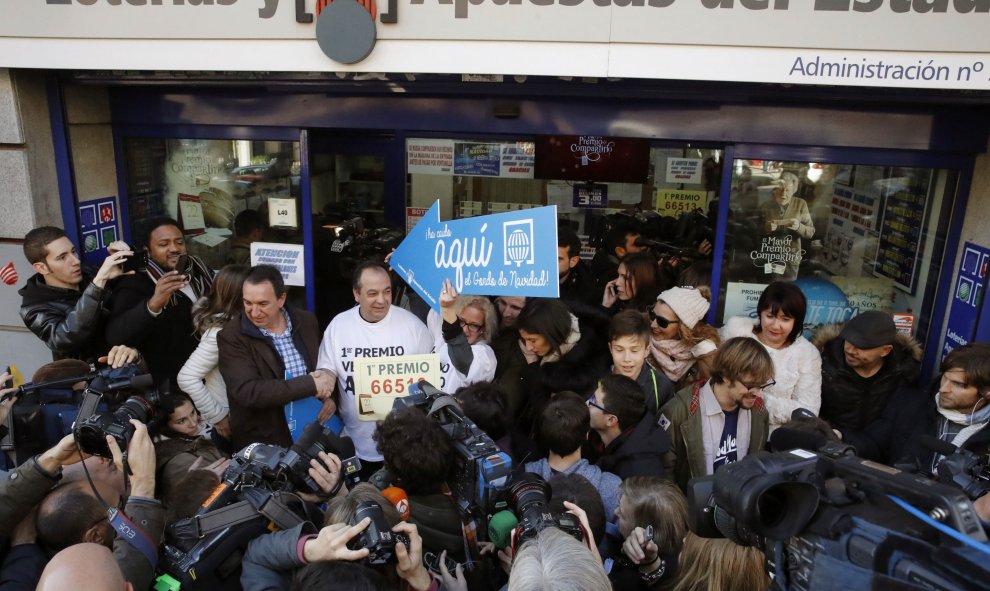 Decenas de periodistas se aglomeran a las puertas de la administración situada en el Paseo de la Esperanza, número 4, en Madrid, donde ha sido vendido el número 66.513, agraciado con el Gordo de Navidad.  EFE/Juan Carlos Hidalgo