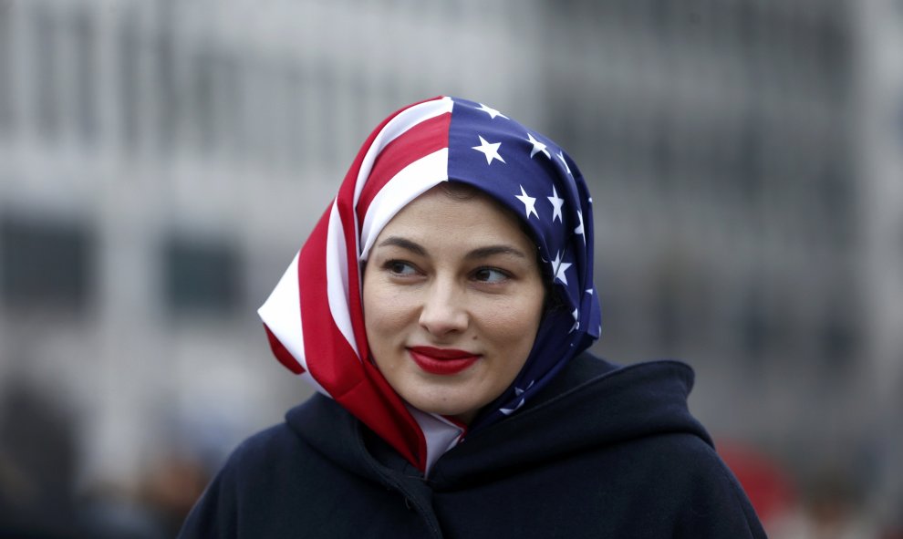 Una mujer musulmana con un velo con la bandera de Estados Unidos en la concentración contra Trump en Berlín / REUTERS
