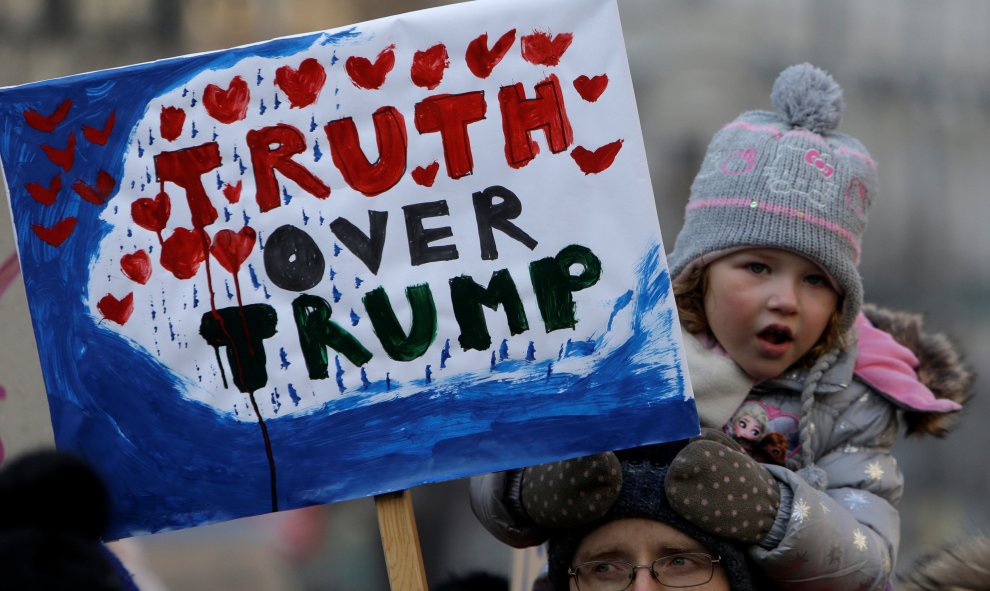 Una niña sostiene una pancarta contra Trump donde se lee "Truth over Trump"  en Praga / REUTERS
