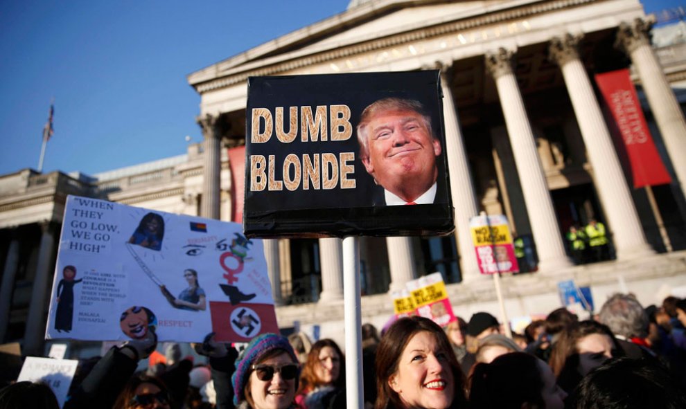 Una manifestante en Londres muestra esta pancarta en la que se puede leer: 'Dumb blonde'.- REUTERS