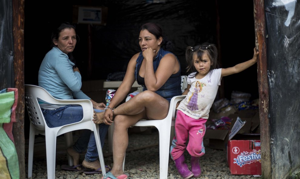 Dos guerrilleras de las FARC descansan junto a una niña en la zona veredal de La Elvira, en el Cauca, Colombia.- JAIRO VARGAS