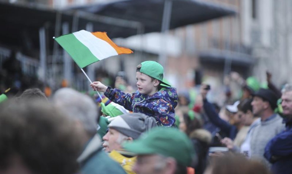 Un niño porta una bandera de Irlanda durante la celebración de la festividad de San Patricio. EFE/Aidan Crawley