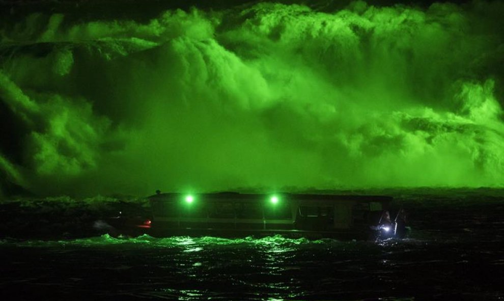 Vista de un barco delante de un espectáculo con luces verdes durante las celebraciones a vísperas del Día de San Patricio en Neuhausen am Rheinfall, Suiza.EFE/ Ennio Leanza