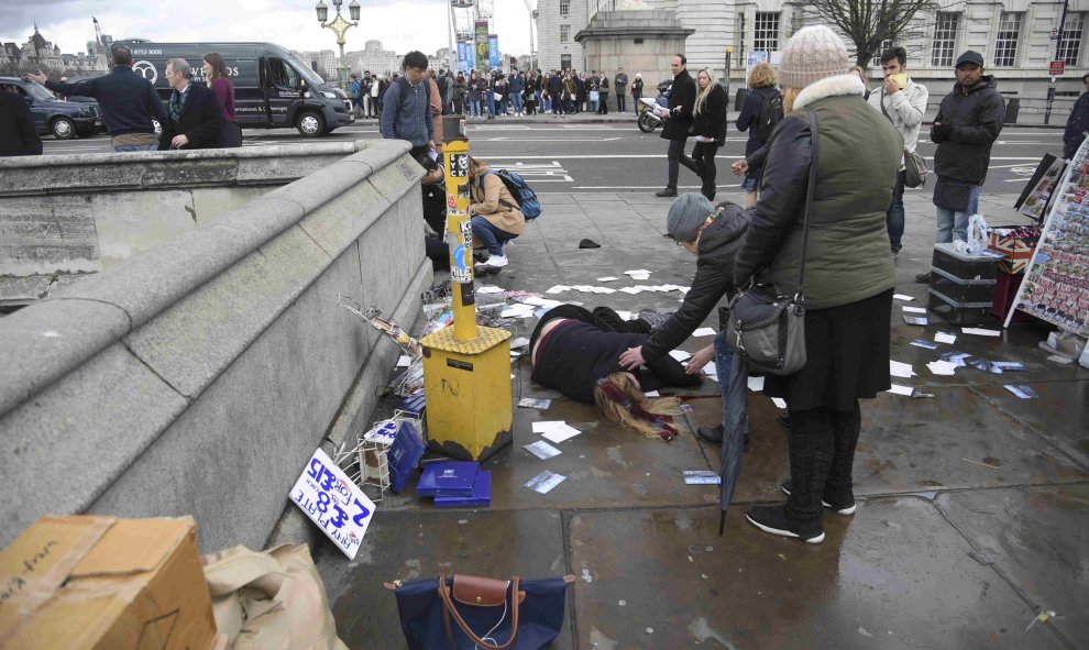 Una mujer yace en el suelo tras el ataque cerca del Parlamento de Londres. REUTERS/Toby Melville