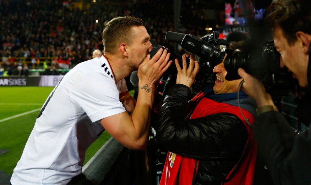 El jugador Lukas Podolski besa a un cámara de televisión tras su aparición final en el partido de la selección alemana contra la inglesa. REUTERS