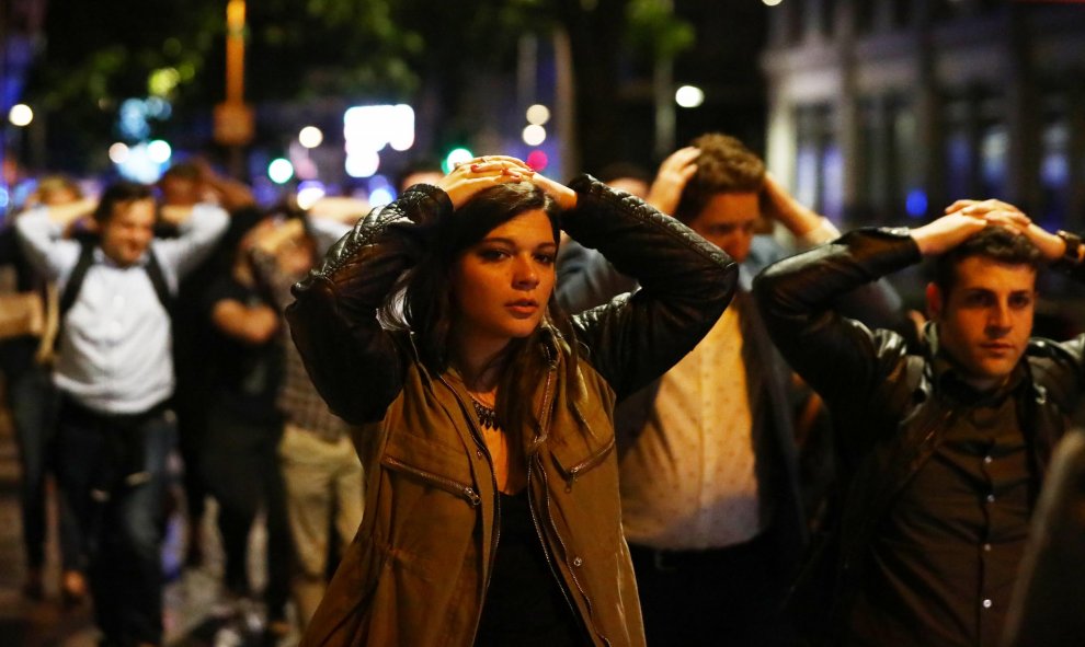 La gente abandona el área del atentado con las manos en alto. REUTERS/ Neil Hall